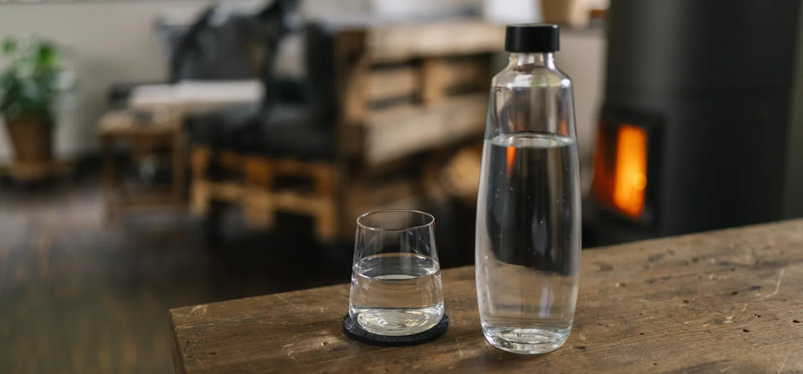 Detailaufnahme von Wasserflasche im Studio mit Kamin im Hintergrund